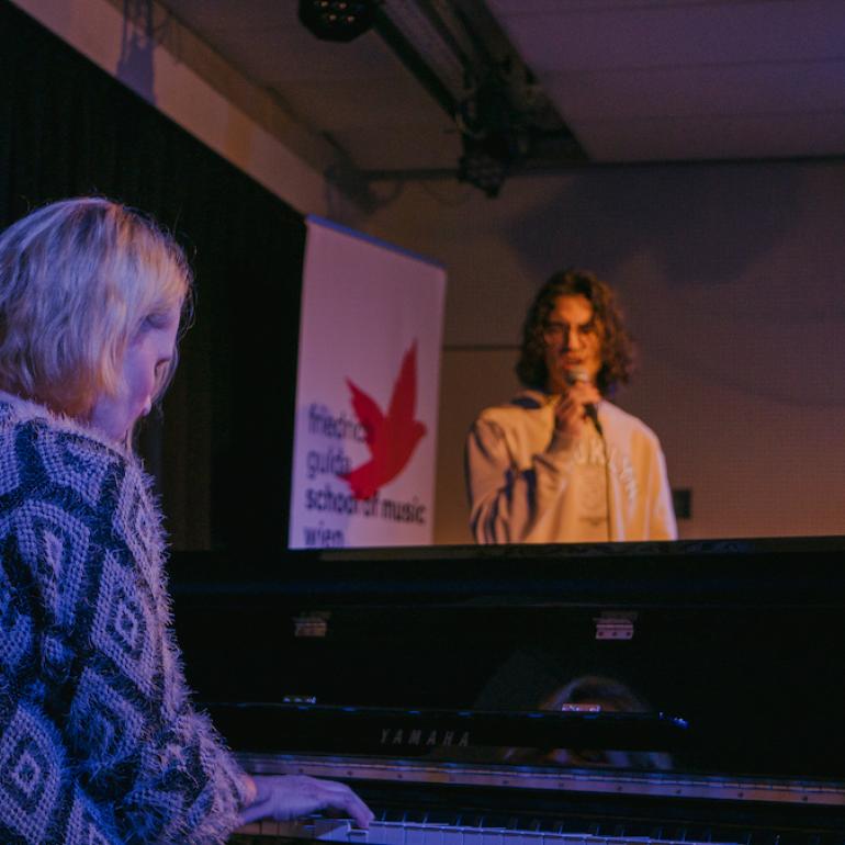 Student singt, während Monika Herzig Klavier spielt